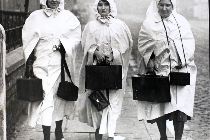 Manchester maternity nurses wearing their new voluminous white capes and hoods, to be more easily seen in the blackout