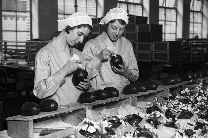 Two women at the Cadbury's chocolate factory in Bournville, in the West Midlands join together chocolate Easter egg halves.