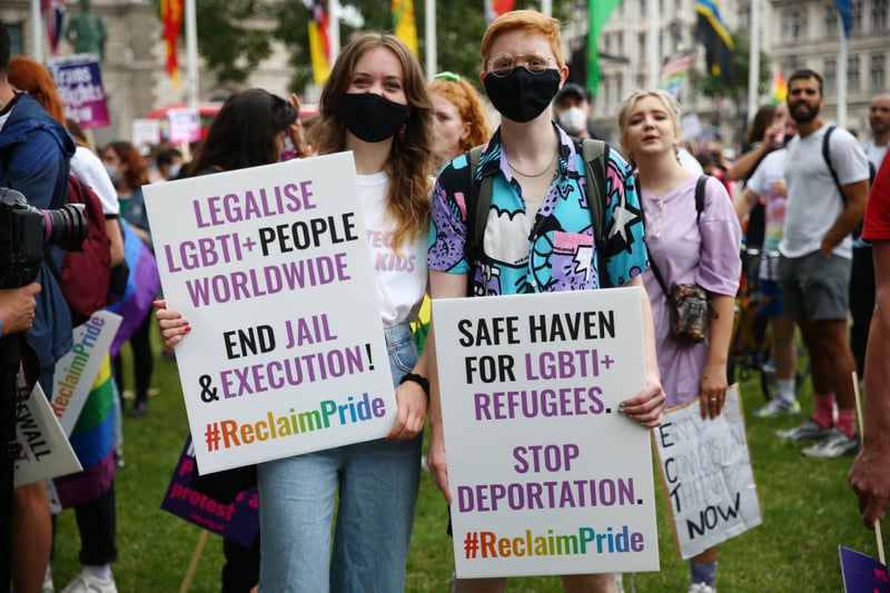 Demonstrators hold placards during a Reclaim Pride March on July 24, 2021 in London, England. 