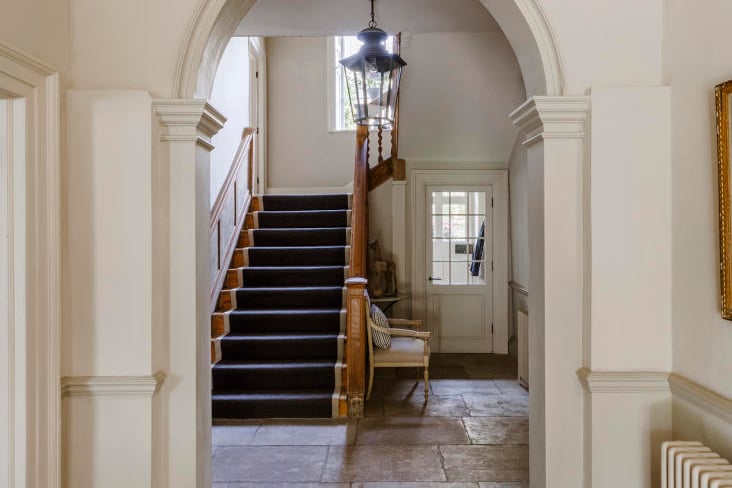 Pass through the front door into a hall extending the depth of the building with a classical stucco arch, as well as antique grey limestone flagstones underfoot.