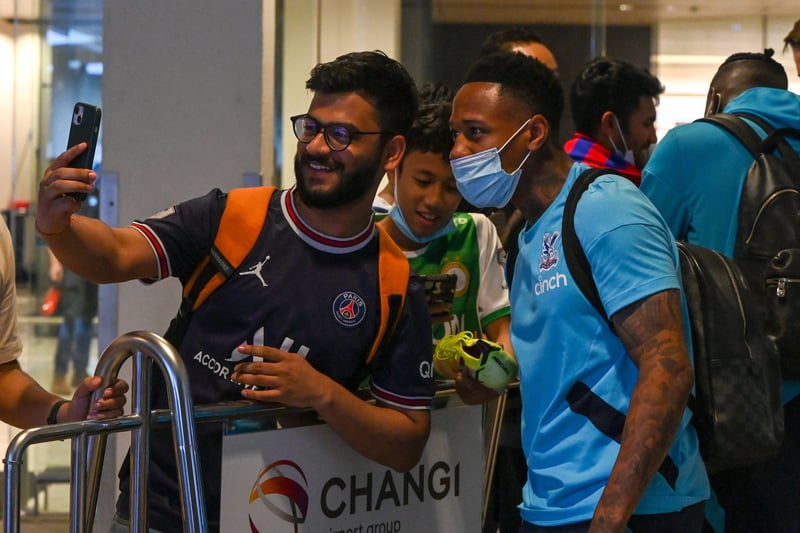 Crystal Palace player Nathaniel Clyne poses for a selfie with a fan upon arrival at Changi International Airport in Singapore.