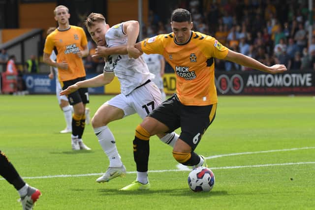 Dan Kemp battles with Lloyd Jones as MK Dons struggle to make an impression on Cambridge United in the first half at the Abbey Stadium