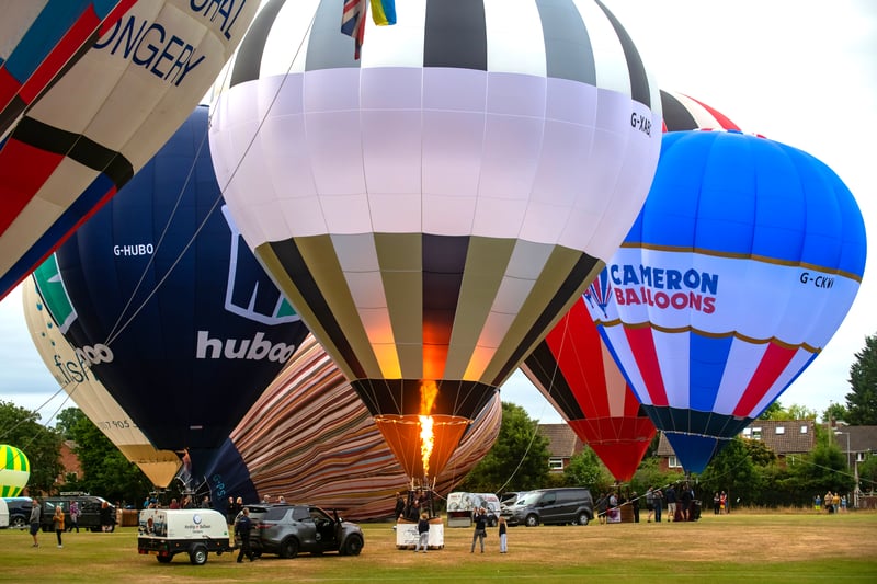 Pilots are briefed on the weather for the first ascent before the balloons prepare, inflate and ascend over the city.