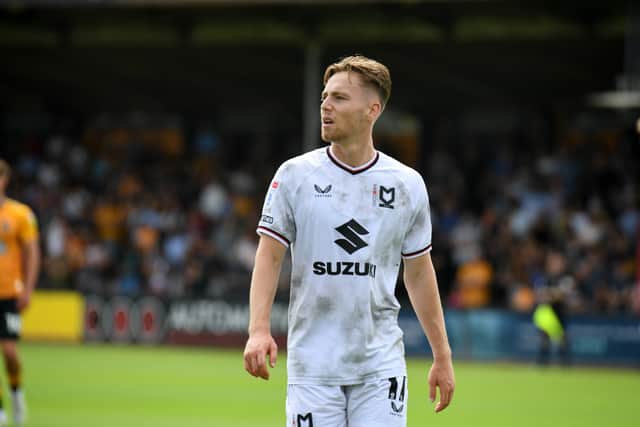 Dan Kemp in the new Castore MK Dons kit which has had its critics since launching last month