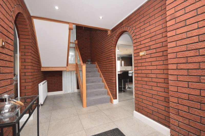 The modern entrance has a gorgeous tile floor, exposed brick and high ceilings.