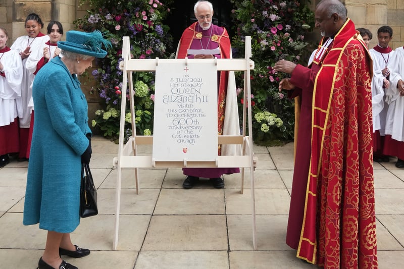 Queen Elizabeth II is shown a plaque commemorating her visit by Dean of Manchester Cathedral, Rogers Govender 