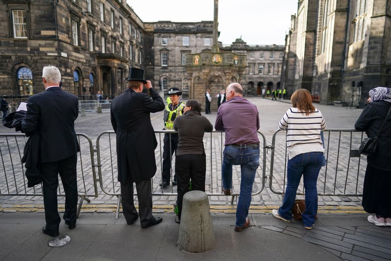 Members of the public wait on the Royal Mile to view the cortege carrying the coffin of the late Queen Elizabeth II   
