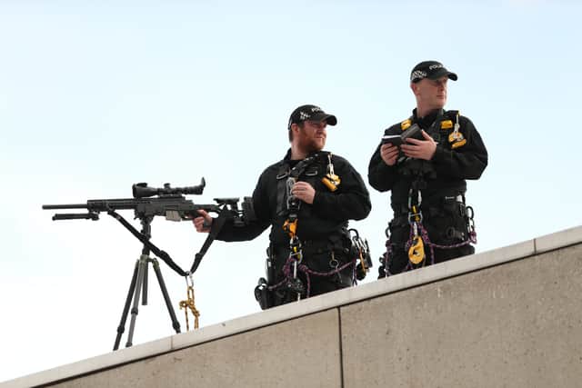 Firearms officers keep watch in Edinburgh ahead of the arrival of Queen Elizabeth II’s coffin
