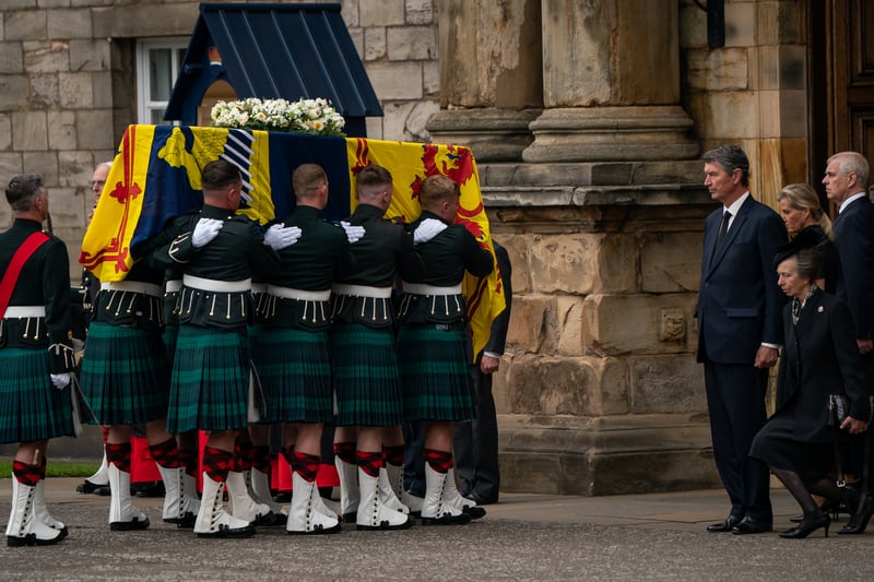 The Princess Royal curtseys the coffin of Queen Elizabeth II, draped with the Royal Standard of Scotland, as it arrives at Holyroodhouse.