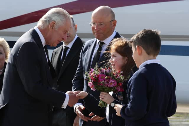 King Charles III is greeted by Ella Smith and Lucas Watt, both 10, as he arrives at Belfast City Airport in Northern Ireland. 
