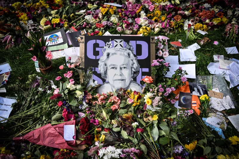 Queen Elizabeth against graphic purple writing surrounded by photographs, drawings and flowers.