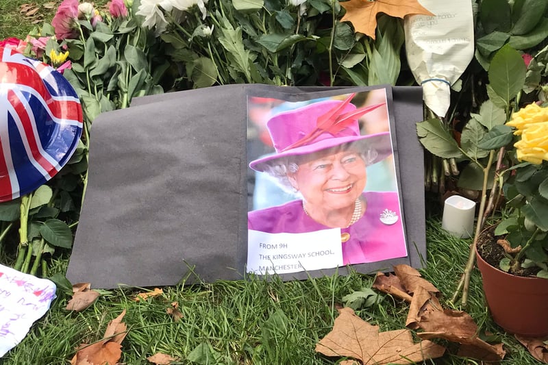 The Queen - dressed in bright pink - smiles in this card from schoolchildren among the flowers in Green Park, central London.