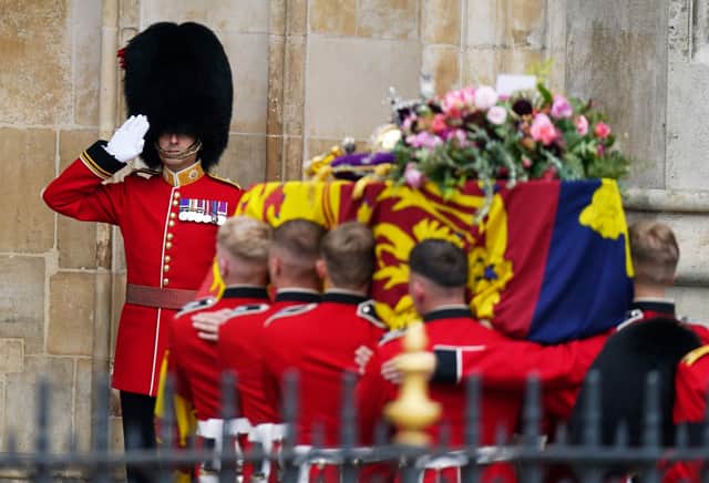 The coffin of Queen Elizabeth II, draped in the Royal Standard with the Imperial State Crown and the Sovereign's orb and sceptre, is carried into Westminster Abbey during State Funeral. Picture date: Monday September 19, 2022.