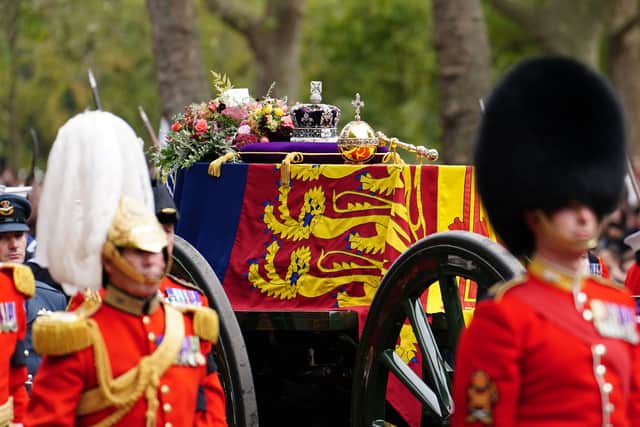The State Gun Carriage carries the coffin of Queen Elizabeth II, draped in the Royal Standard with the Imperial State Crown and the Sovereign's orb and sceptre, in the Ceremonial Procession down The Mall, following her State Funeral at Westminster Abbey, London. Picture date: Monday September 19, 2022.