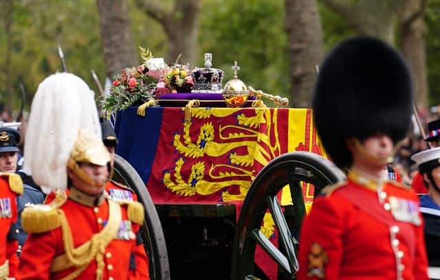 The State Gun Carriage carries the coffin of Queen Elizabeth II, draped in the Royal Standard with the Imperial State Crown and the Sovereign's orb and sceptre, in the Ceremonial Procession down The Mall, following her State Funeral at Westminster Abbey, London. Picture date: Monday September 19, 2022.