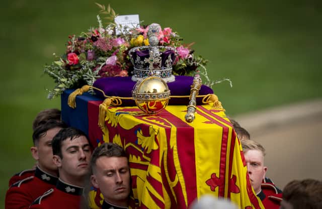 The bearer party carry the coffin of Queen Elizabeth II, draped in the Royal Standard with the Imperial State Crown and the Sovereign's orb and sceptre, to the state herse for it's journey to Windsor Castle following her State Funeral at Westminster Abbey, London.