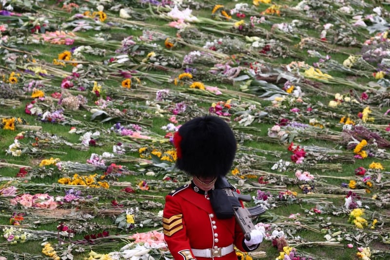 A Beefeater stands guard on the day of the state funeral and burial of Britain’s Queen Elizabeth, at Windsor Castle, in front of flowers lain for Her Majesty, Credit: HENRY NICHOLLS/POOL/AFP via Getty Images