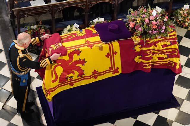 King Charles III places the the Queen’s Company Camp Colour of the Grenadier Guards on the coffin in St George’s Chapel in Windsor Castle. Picture: PA.