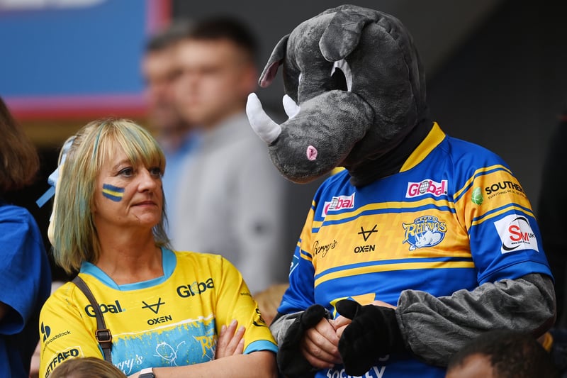 A fan of Leeds Rhinos stands with a fellow fan, wearing a Rhino costume.  (Photo by Gareth Copley/Getty Images)