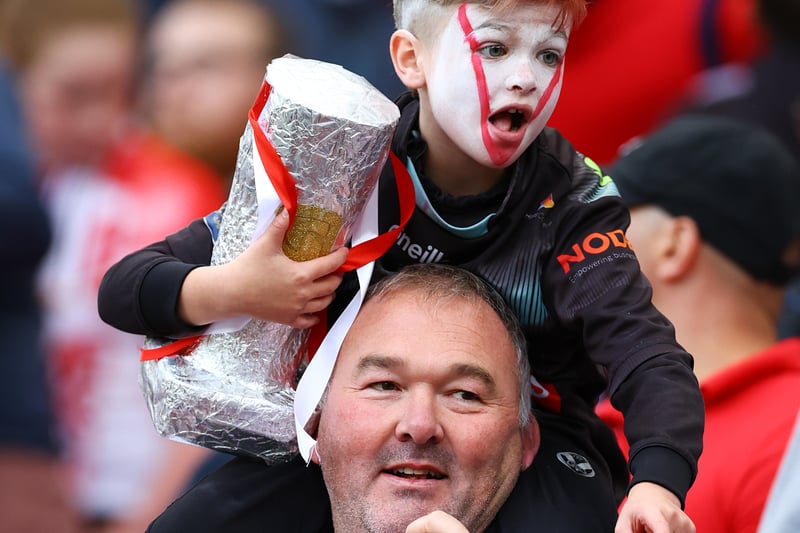 A young fan of St Helens carries a replica of the Grand Final Trophy prior to kick off. (Photo by Michael Steele/Getty Images)