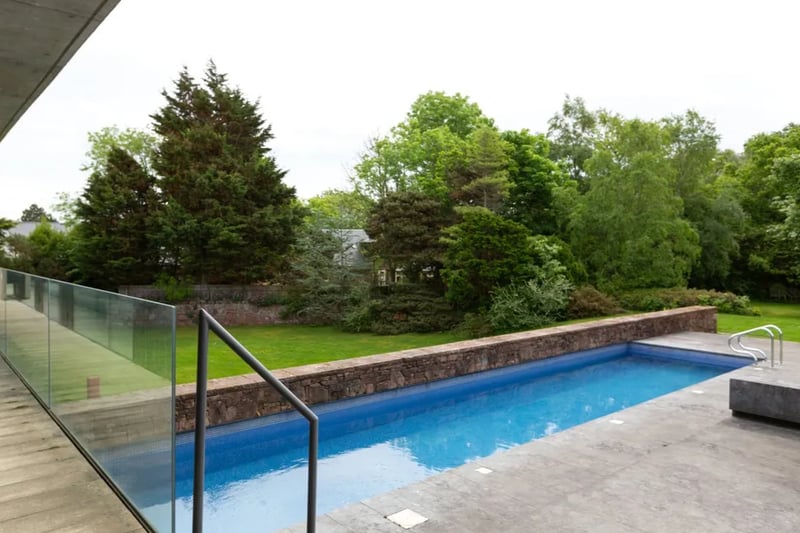 The house appears to hover over the pool, which runs away from the property and into the grounds.