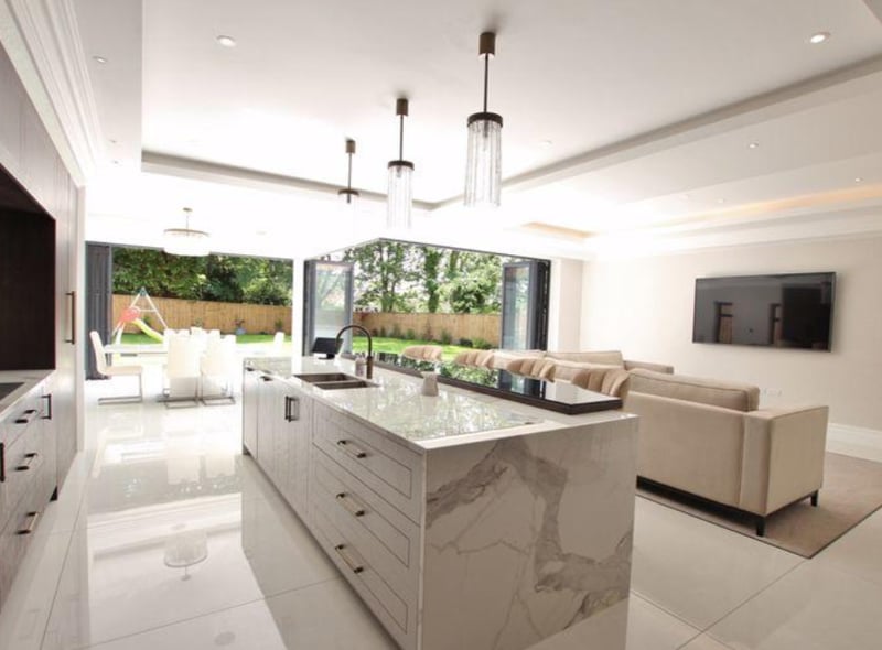The sophisticated property has plenty of natural light, especially in the open plan kitchen/living space. The modern kitchen fixtures include a marble island counter and large family refrigerator.
