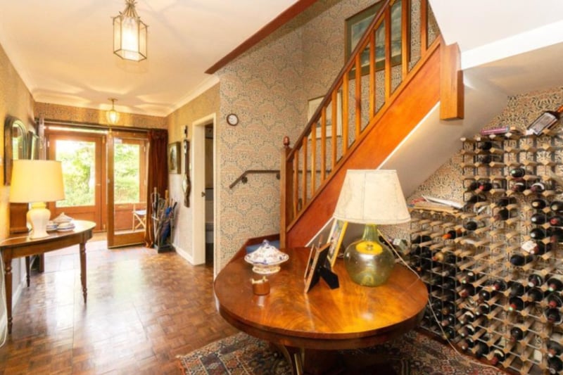 The large hallway features a magnificent wine rank and classic wooden features. 