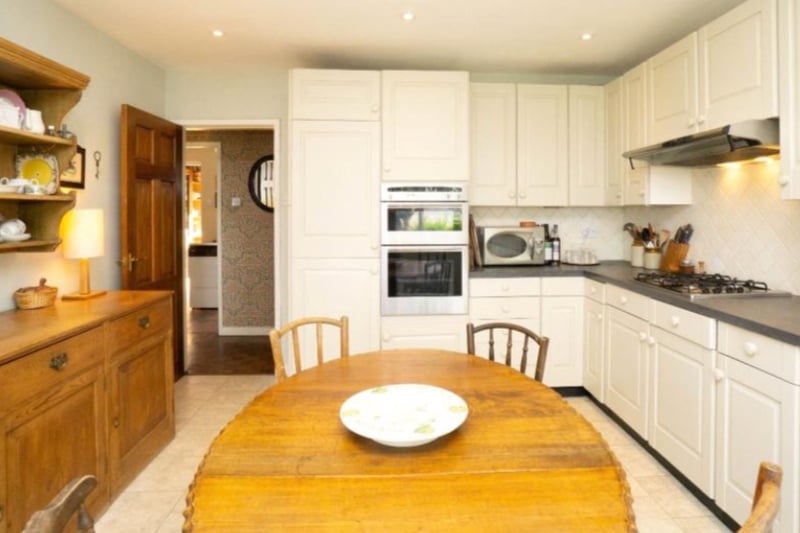 The kitchen is a mix of classic and modern, with a mix of white and brown fixtures.