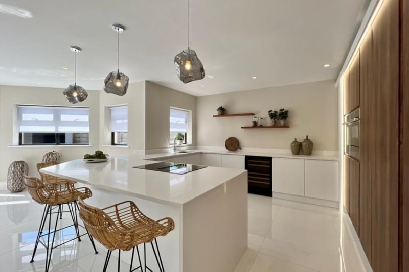The kitchen features modern fixtures, a breakfast bar and gorgeous wooden cabinets.