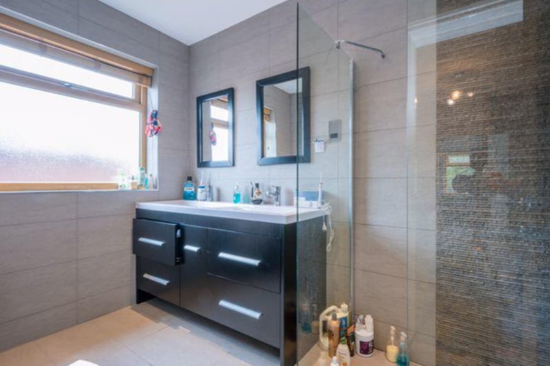 The master bedroom’s en-suite is modern and features a large, walk-in shower. 