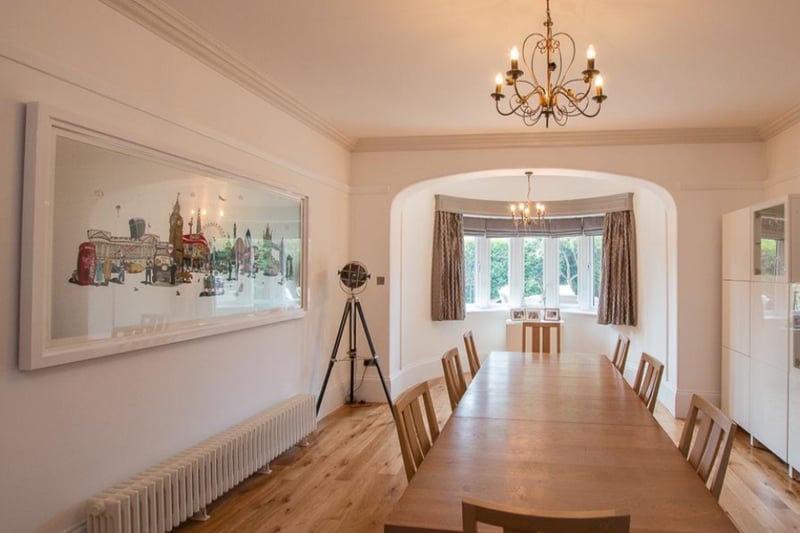 The large dining area has wooden floors, a quirky radiator and another bay window.