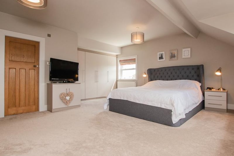 The master bedroom has large fitted wardrobes and an en-suite bathroom.