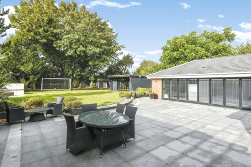 The large garden features a large lawned area with luxurious seating area, a fire pit BBQ area with kitchen and a ‘man cave’ bar,