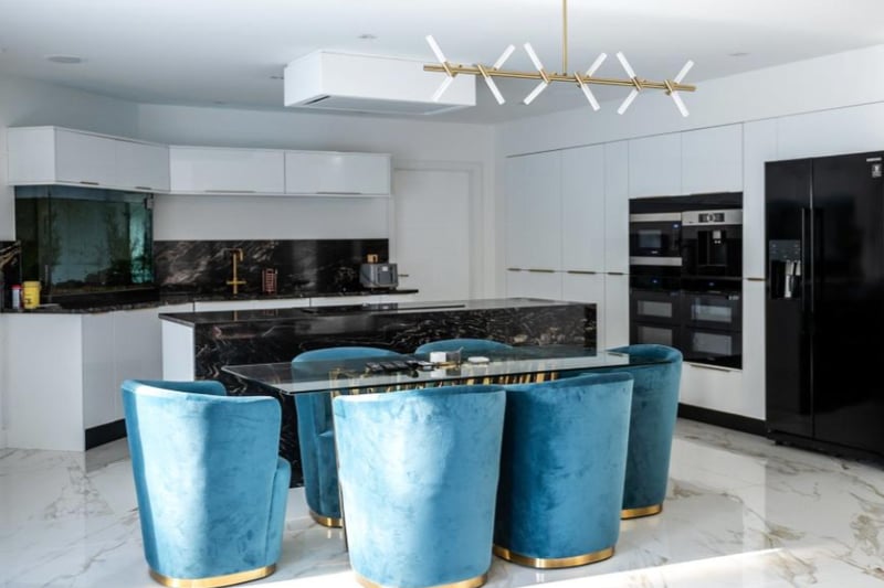 The modern kitchen features stunning black work tops and fitted appliances.
