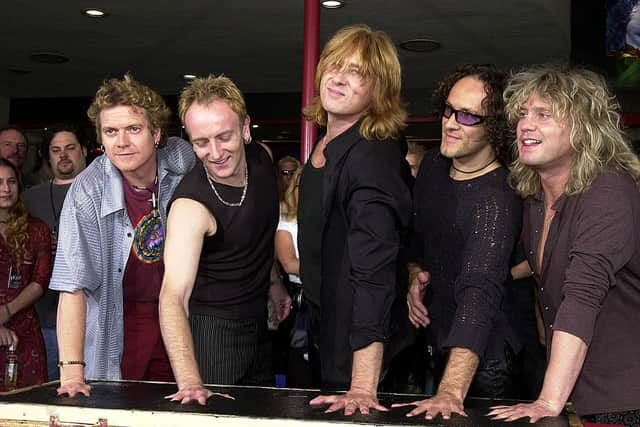Def Leppard make their handprints to be put in the Rockwalk on the sidewalk in Hollywood. (Photo by LUCY NICHOLSON/AFP via Getty Images)