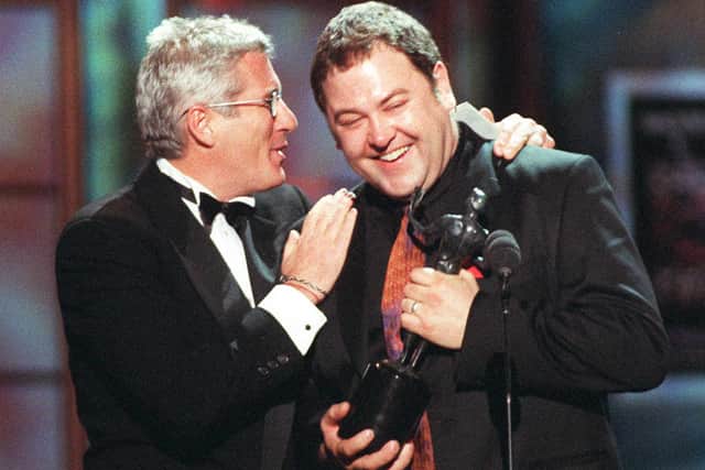 US actor Richard Gere (L) congratulates English actor Mark Addy, who accepted the award for outstanding performance by a cast in a theatrical motion picture for the film "The Full Monty", during the 4th Annual Screen Actor Guild Awards 08 March in Los Angeles. The film has also been nominated for best picture at this year's Academy Awards.  (Photo credit should read HAL GARB/AFP via Getty Images)