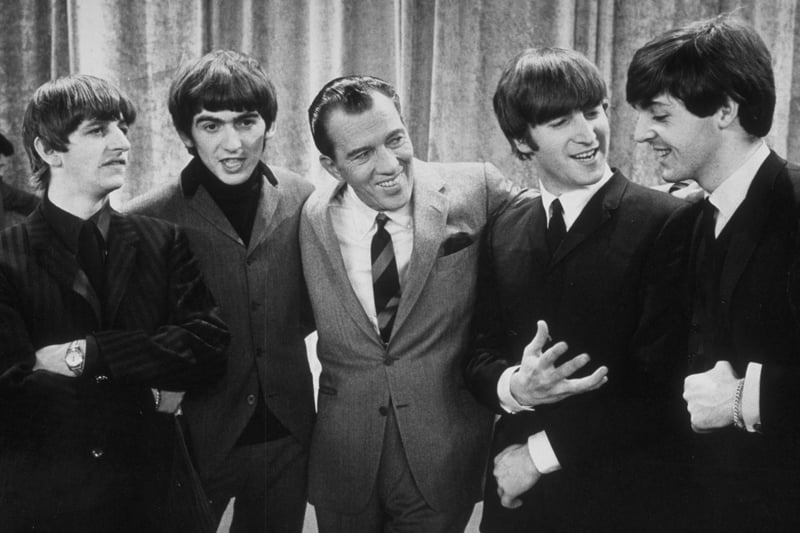 On February 9, 1964, The Beatles made history when they performed in America for the first time on “The Ed Sullivan Show. American television host Ed Sullivan smiles while standing with the Beatles on the set of his television show. 