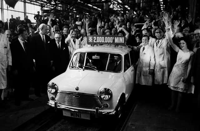 Workers cheer as the two-millionth Mini rolls off the production line at Longbridge, Birmingham in May 1969, the plant of British Leyland’s Austin Morris division. George Turnbull, managing director of the division sits at the wheel, next to Alec Issigonis, designer of the Mini.   (Photo by Keystone/Getty Images)