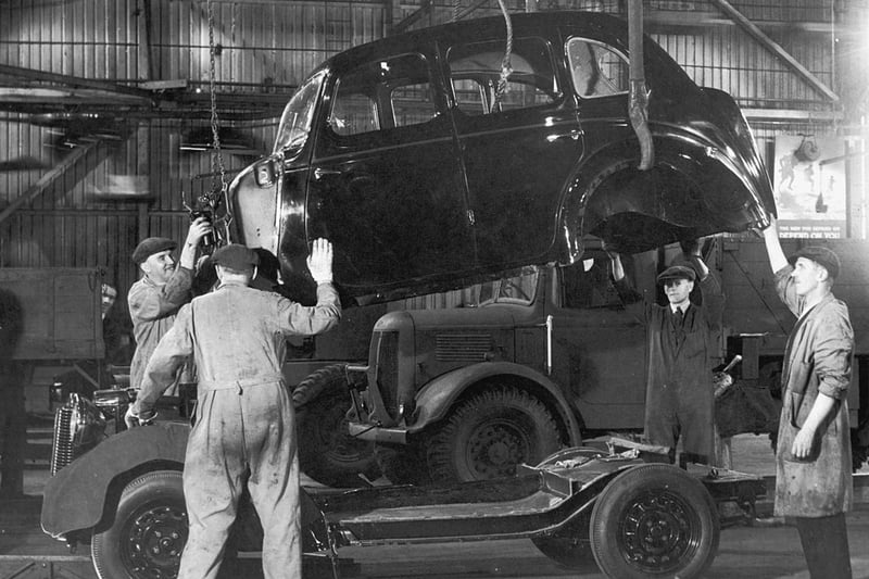 The body of a 10h.p. Austin car is lowered onto its chasis at the Austin Motor Company’s Longbridge plant in Birmingham, 28th August 1945. (Photo by William Vanderson/Keystone/Hulton Archive/Getty Images)