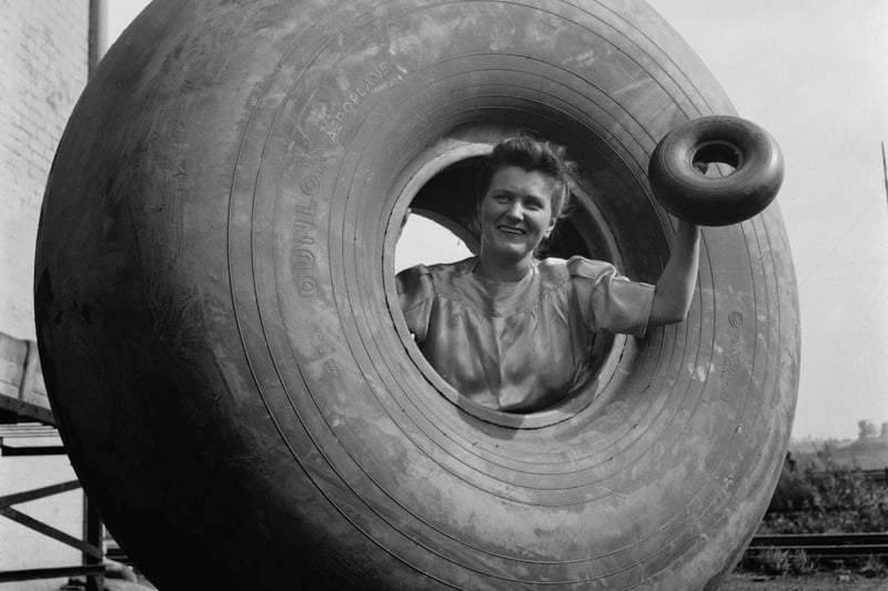  A woman inside a Dunlop aeroplane tyre and holding a smaller tyre in Birmingham, England, during World War II, August 1941. From a Ministry of Information special on Birmingham. (Photo by Fred Ramage/Keystone Features/Hulton Archive/Getty Images)