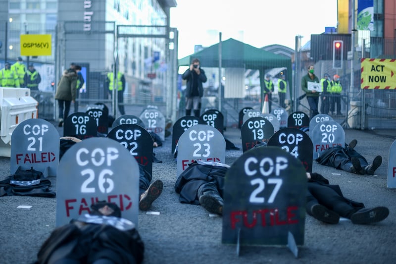 Extinction Rebellion protesters are seen during a die in protest outside the entrance to the COP26