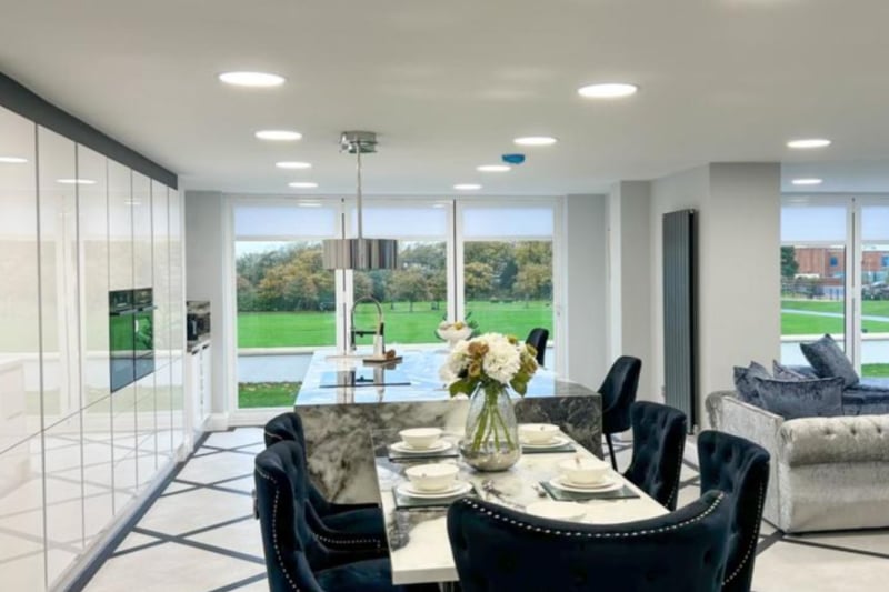 The large kitchen/dining area features modern fitted cabinets, spotlights and views of the garden. 