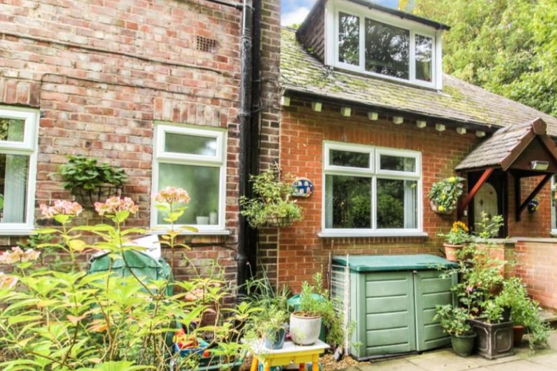 The three-bed property has a cottage like feel, surrounded by shrubbery.