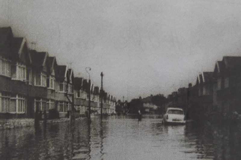 Hendre Road submerged. A resident can be seen crossing the street.