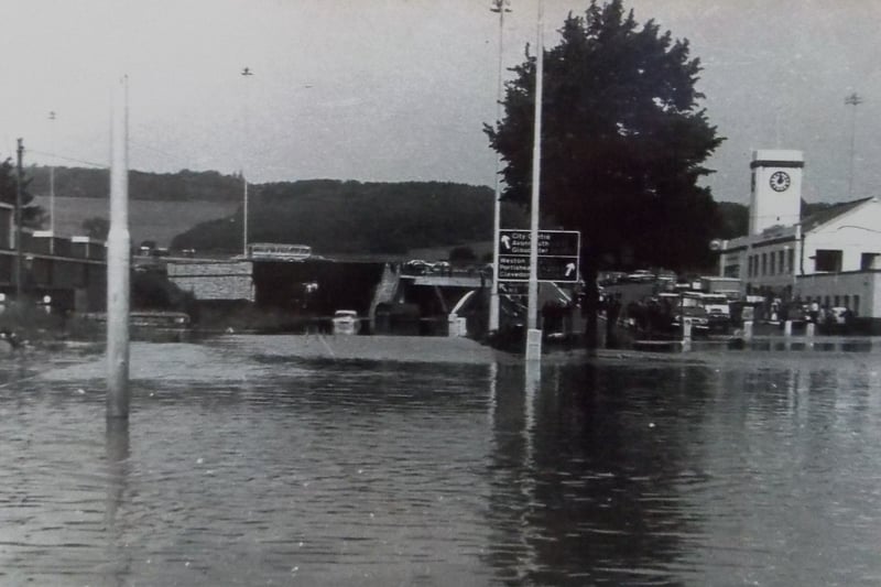 Signs for the city centre stand above a flooded Winterstoke Road. 