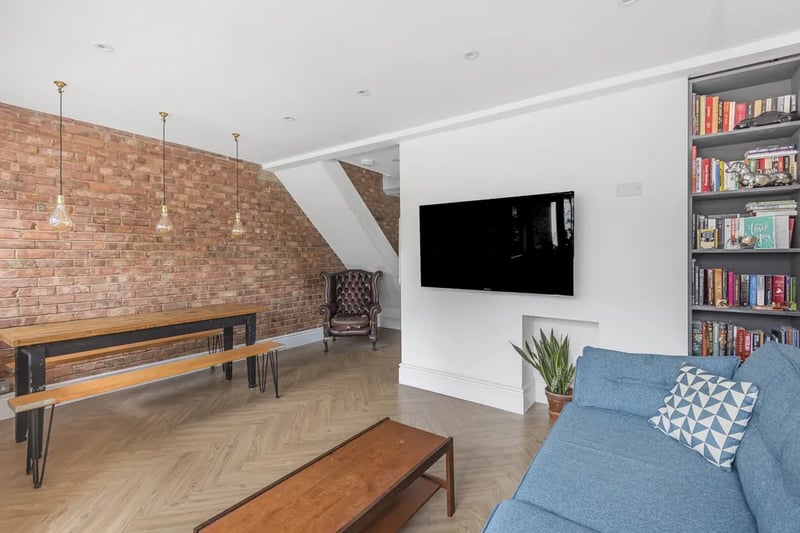 The reception room features exposed brick walls, wooden floors and modern furnishings