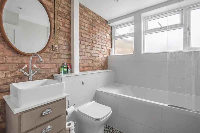 A refurbished bathroom, including a deep sink and combined bath/shower