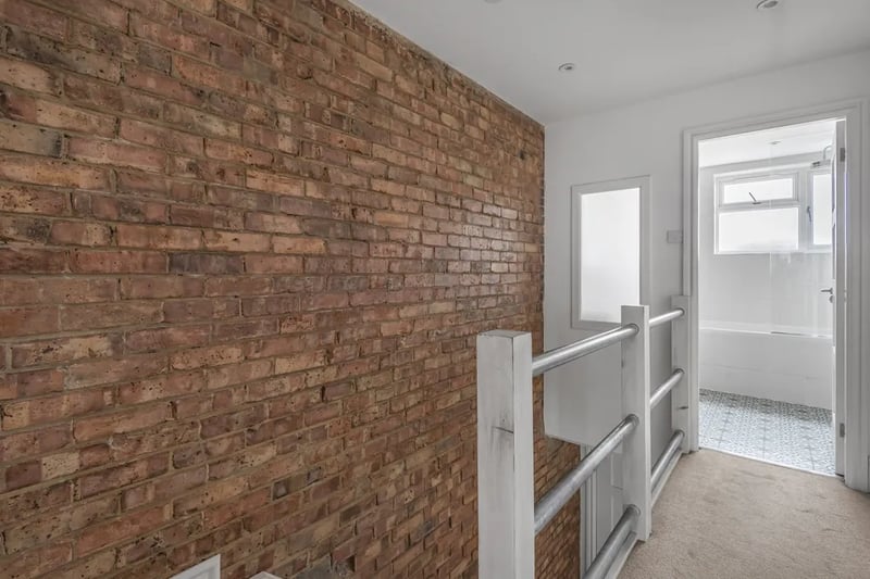 The exposed brick walls continue throughout the second level of the maisonette where the bedroom and bathroom is placed