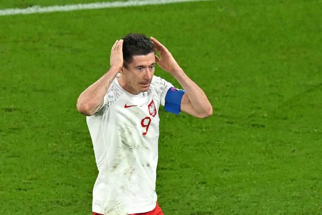 Robert Lewandowski reacts after having his penalty saved (AFP via Getty Images)