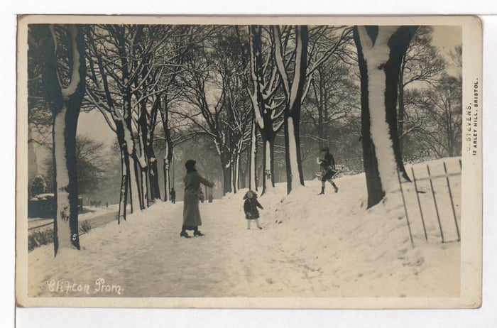 A fun snow scene showing a mum and her children having a snowball fight on the Clifton Prom. No date is given.